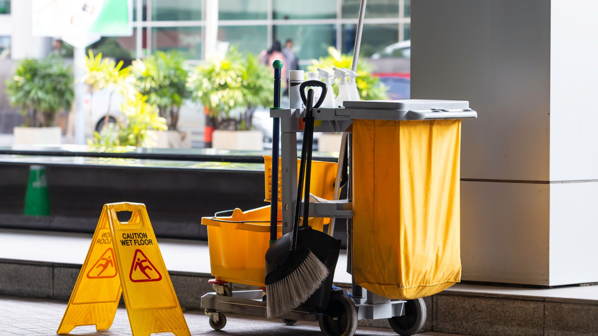 A street sweeper and a yellow caution sign