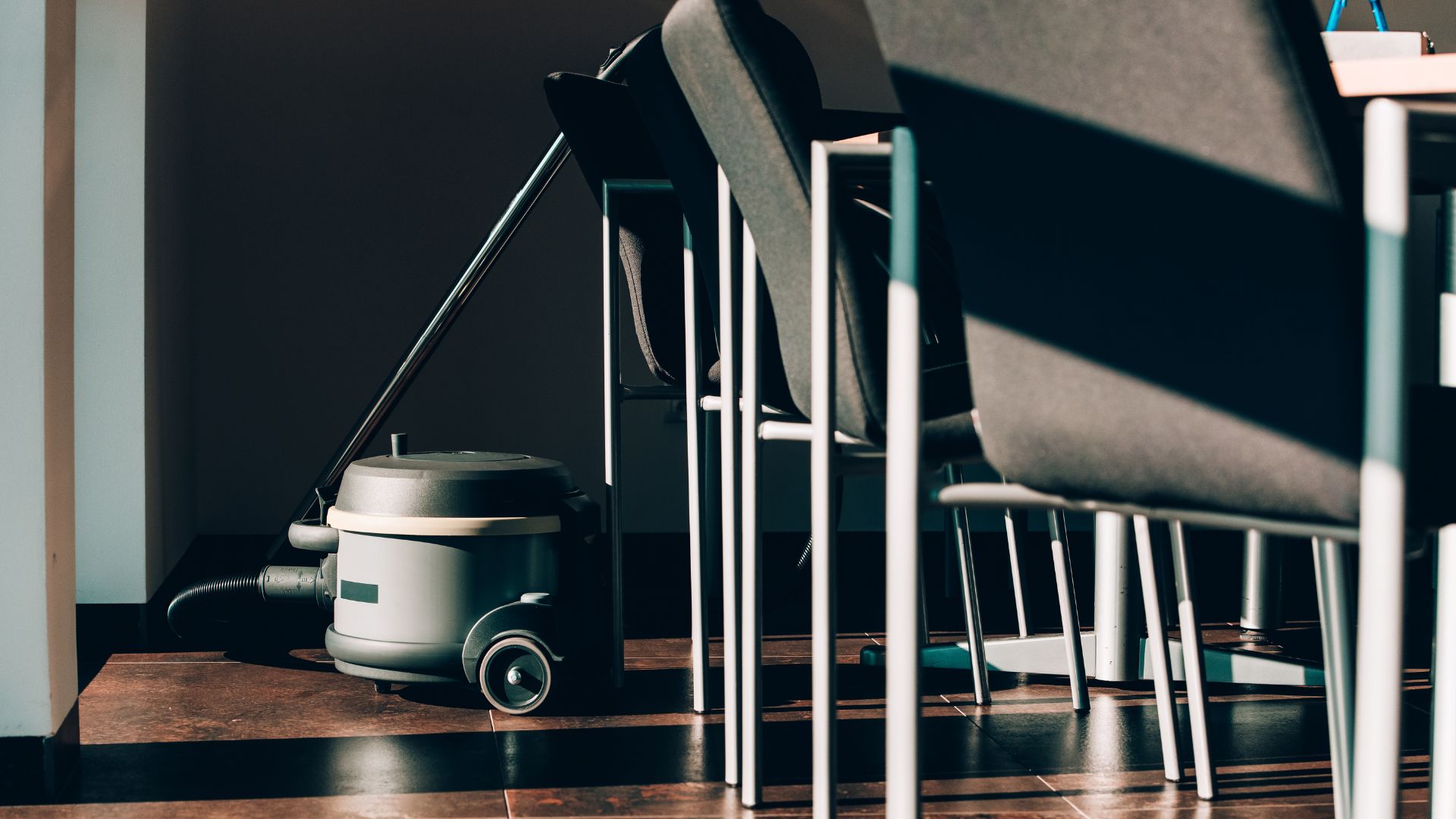 A room with chairs and a vacuum on the floor