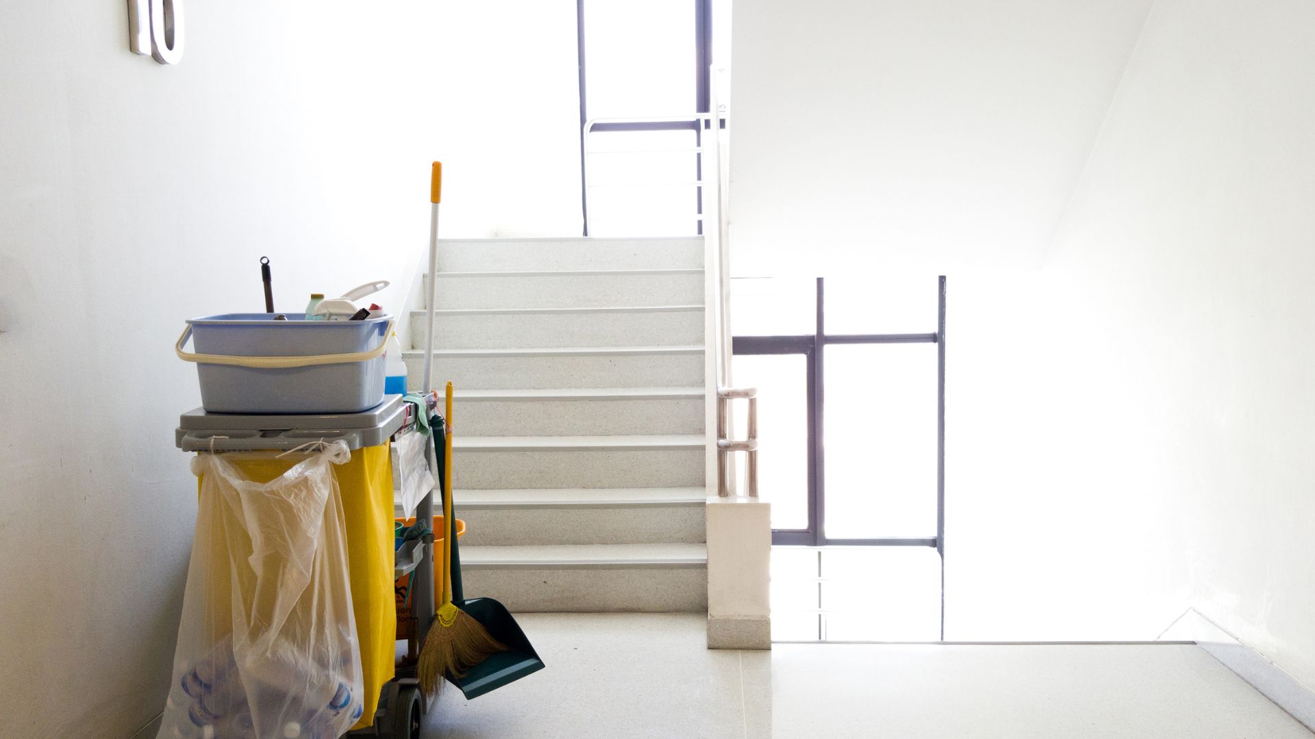 A room with a staircase and a trash can